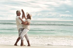 deux couples séniors dansant sur la plage