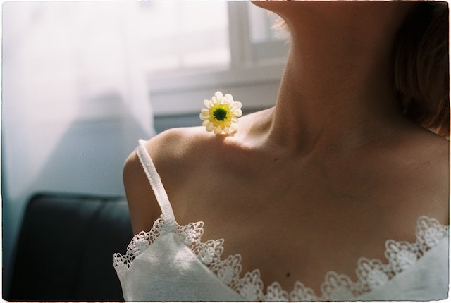 une femme avec une fleur sur son épaule