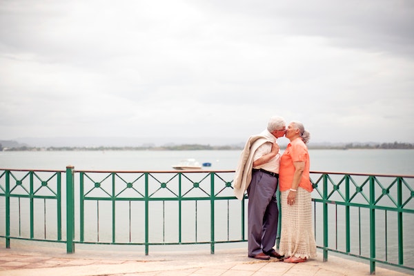 couple agé s'embrassant au bord d'une rivière
